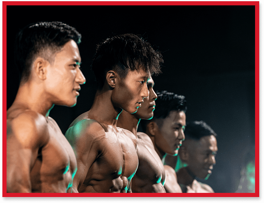 ステージ上で筋肉を披露するフィジーク選手たちの横並びの姿。